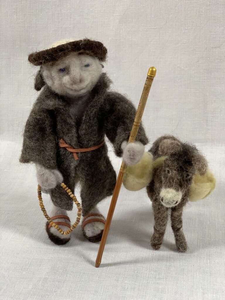 Needle-felted friar with walking staff and beads, accompanied by a laden donkey.